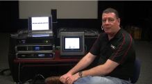 Barry Ferrell Sitting in front of QSC Cinema Hardware for a tutorial